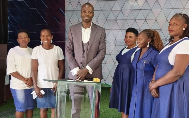 Pastor preaching from the pulpit to the congregation at Tusubira Global Ministries